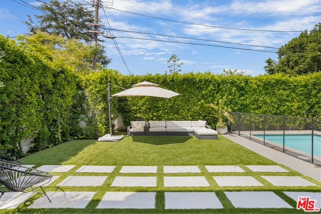 view of yard with outdoor lounge area and a fenced in pool