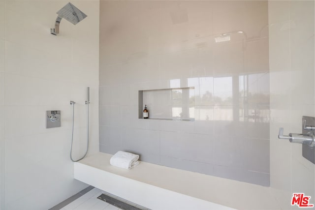 bathroom with tile walls and tiled shower