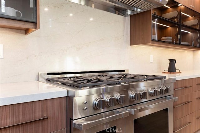 kitchen with premium range hood, tasteful backsplash, and high end range