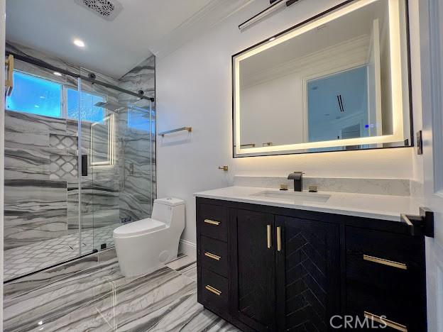 bathroom featuring walk in shower, vanity, and toilet