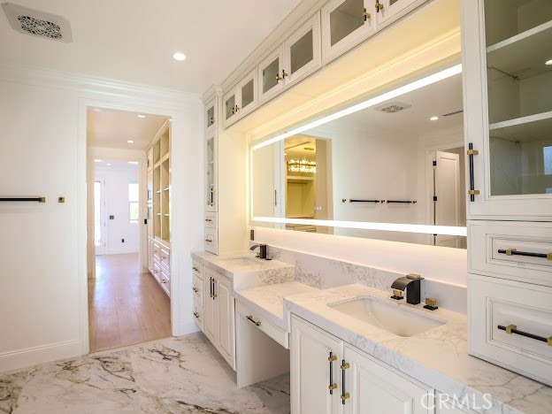 bathroom with wood-type flooring, vanity, and crown molding