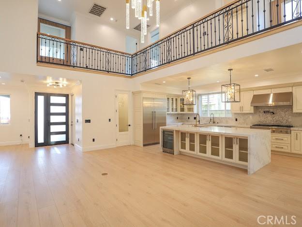 kitchen with a towering ceiling, french doors, light hardwood / wood-style floors, and a center island