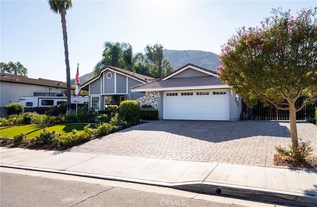 view of front facade with a front yard, a mountain view, and a garage