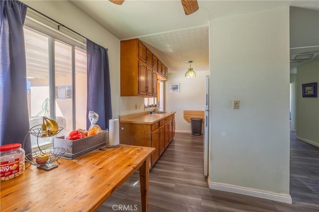 kitchen with pendant lighting, white refrigerator, ceiling fan, sink, and hardwood / wood-style flooring