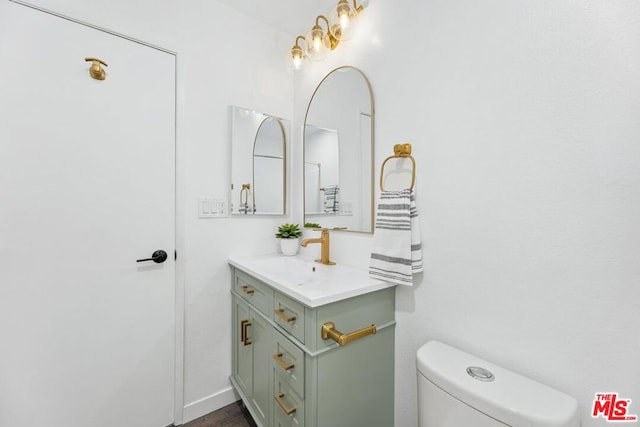 bathroom with hardwood / wood-style floors, vanity, and toilet