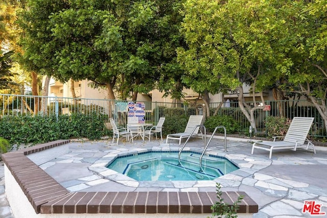 view of pool with a hot tub and a patio area