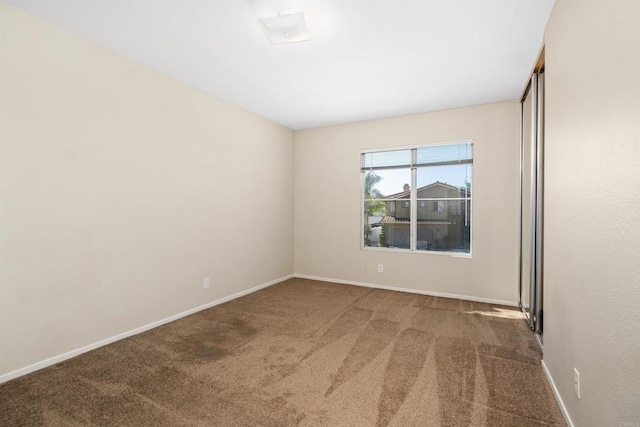 spare room featuring dark colored carpet