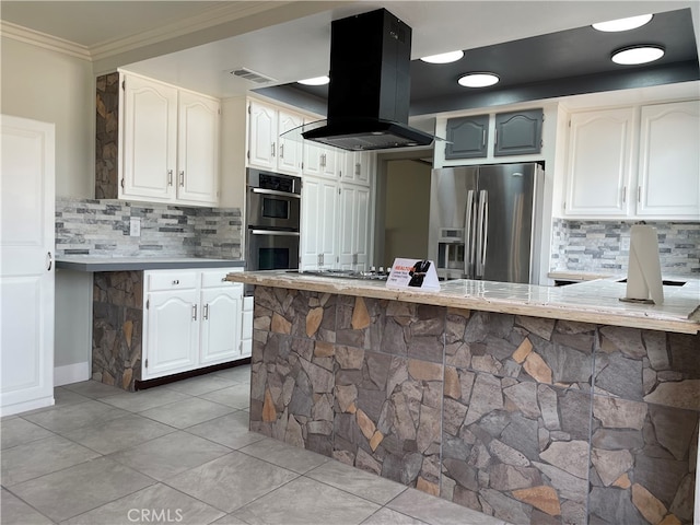 kitchen featuring island range hood, kitchen peninsula, stainless steel appliances, and tasteful backsplash