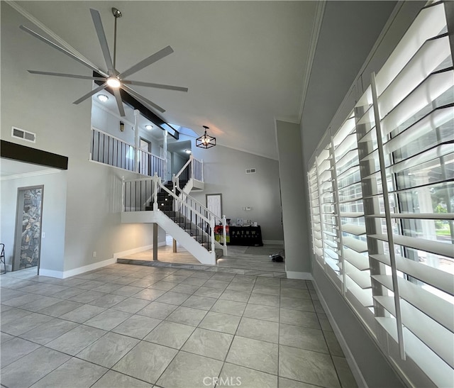 unfurnished living room with ornamental molding, a healthy amount of sunlight, light tile patterned flooring, and high vaulted ceiling