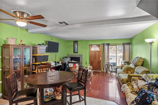 dining space with a textured ceiling, light hardwood / wood-style floors, and ceiling fan