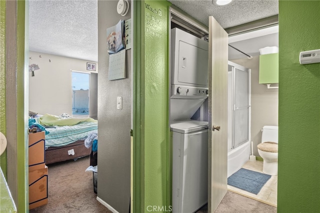 washroom featuring stacked washer / drying machine, light carpet, and a textured ceiling