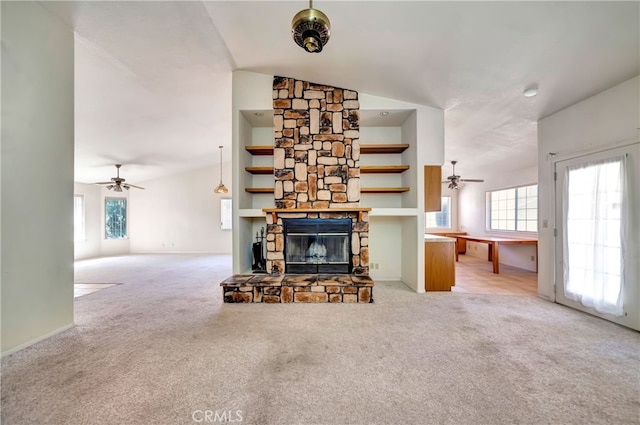 unfurnished living room featuring a fireplace, ceiling fan, vaulted ceiling, and light colored carpet