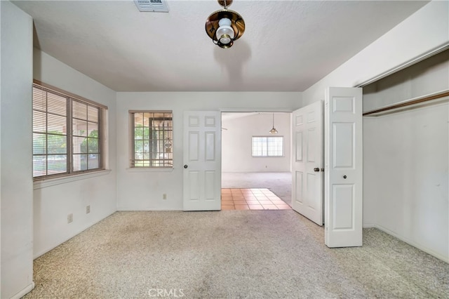 unfurnished bedroom featuring a textured ceiling, a closet, and carpet