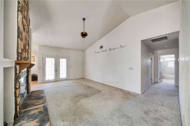 unfurnished living room with carpet floors, vaulted ceiling, and a wealth of natural light