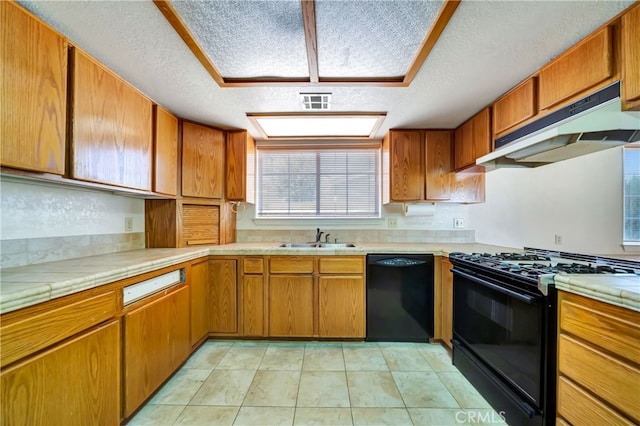 kitchen featuring light tile patterned flooring, black appliances, sink, and a textured ceiling