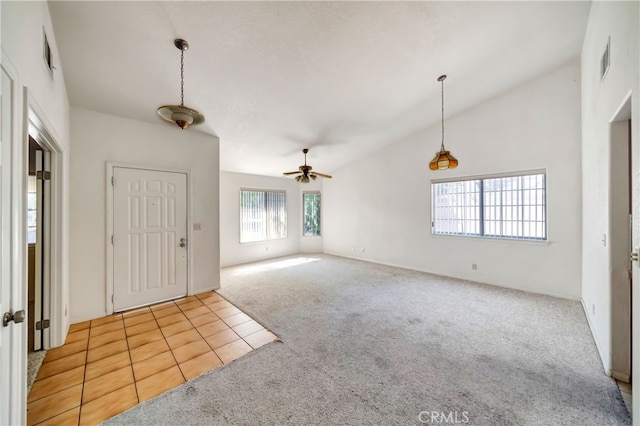 carpeted entryway with high vaulted ceiling and ceiling fan