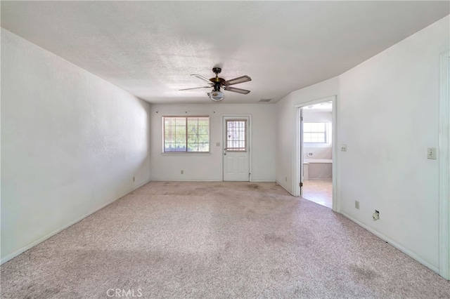 carpeted empty room with ceiling fan and a textured ceiling