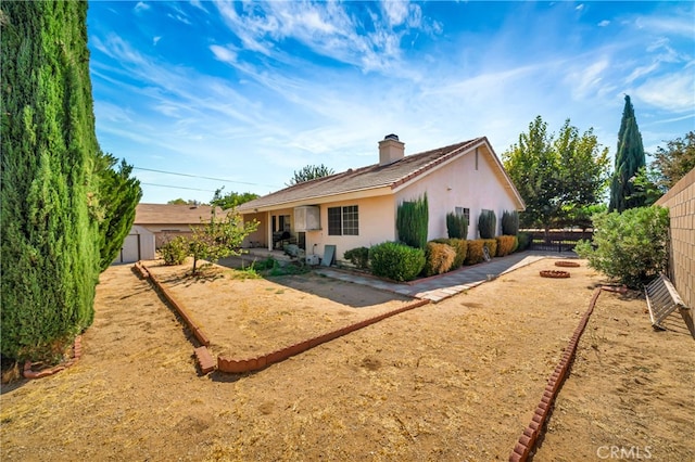 rear view of property featuring a shed and a patio