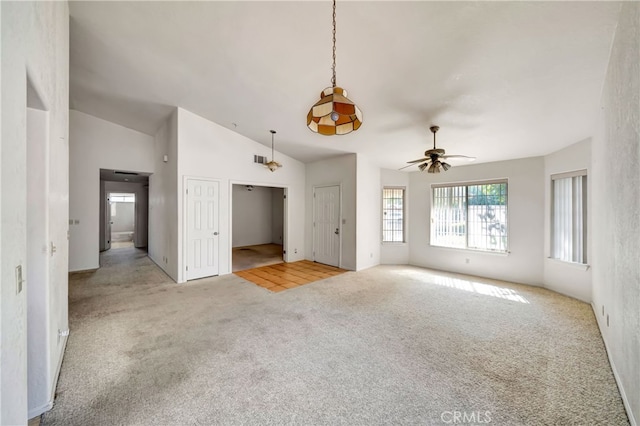 unfurnished living room featuring ceiling fan, vaulted ceiling, and light carpet