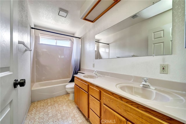 full bathroom featuring vanity, a textured ceiling, shower / bath combo with shower curtain, and toilet