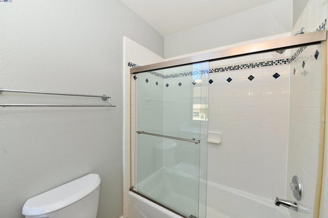 bathroom featuring shower / bath combination with glass door and toilet