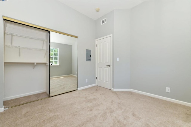 unfurnished bedroom featuring light carpet and a closet