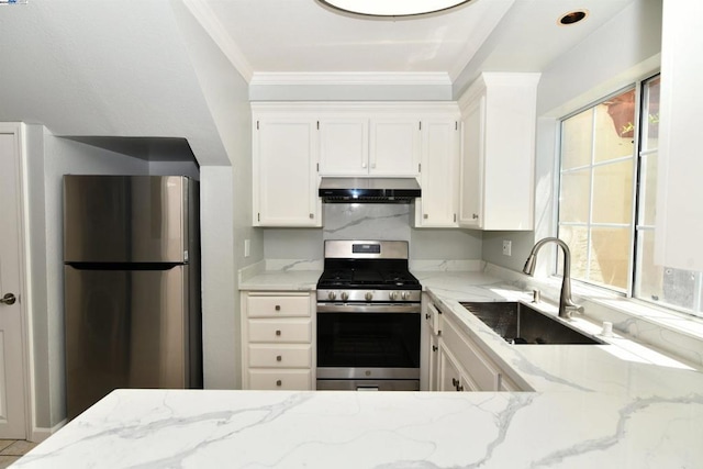 kitchen with plenty of natural light, light stone counters, sink, and appliances with stainless steel finishes