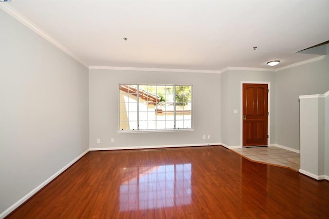 spare room featuring light wood-type flooring and ornamental molding