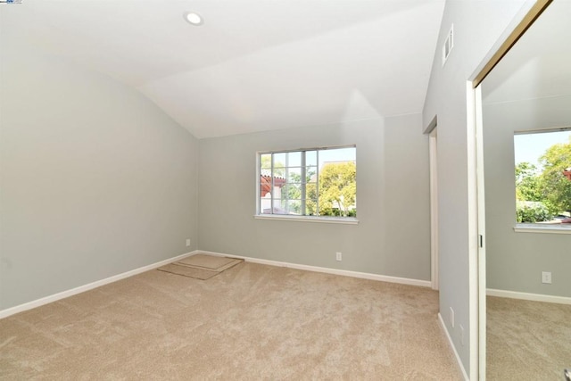 additional living space featuring lofted ceiling and light carpet