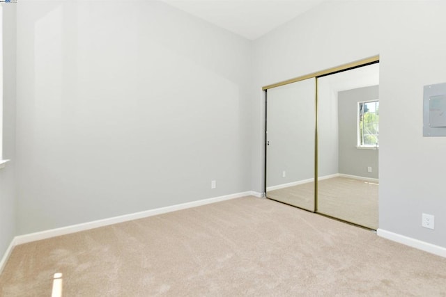 unfurnished bedroom featuring light colored carpet and a closet