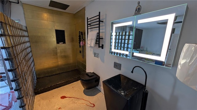 bathroom featuring toilet, ornamental molding, and a tile shower