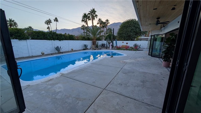 pool at dusk featuring a mountain view