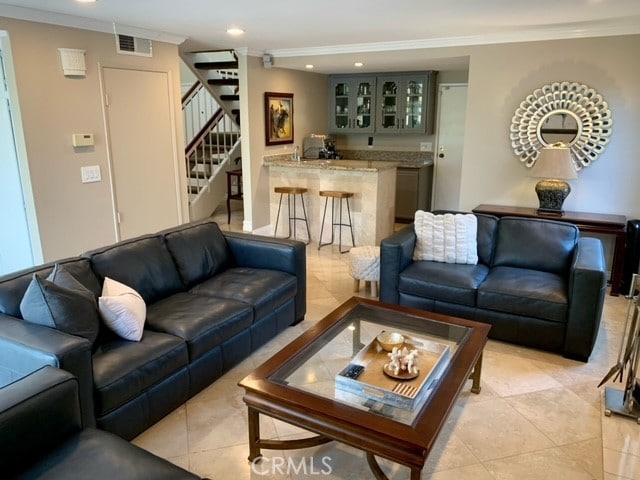 living room featuring crown molding and light tile patterned floors