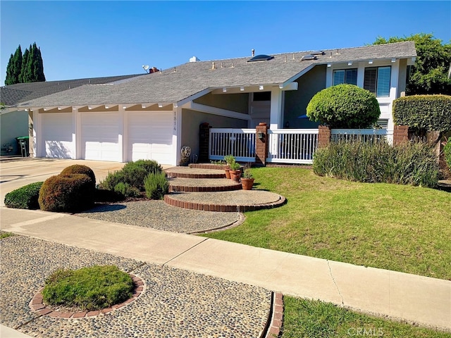 ranch-style home featuring a garage, a front lawn, and covered porch