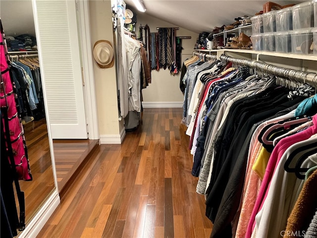 walk in closet featuring lofted ceiling and dark hardwood / wood-style flooring