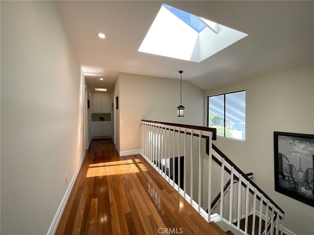 hall featuring lofted ceiling with skylight and dark hardwood / wood-style flooring