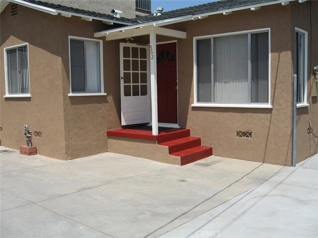 property entrance featuring cooling unit and a patio area