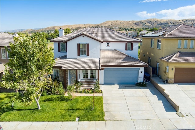 mediterranean / spanish-style house featuring a mountain view, a front lawn, and a garage