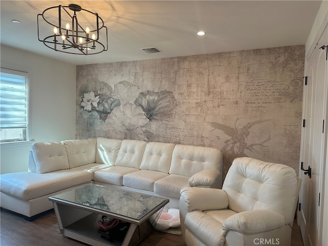 living room with hardwood / wood-style flooring and a notable chandelier