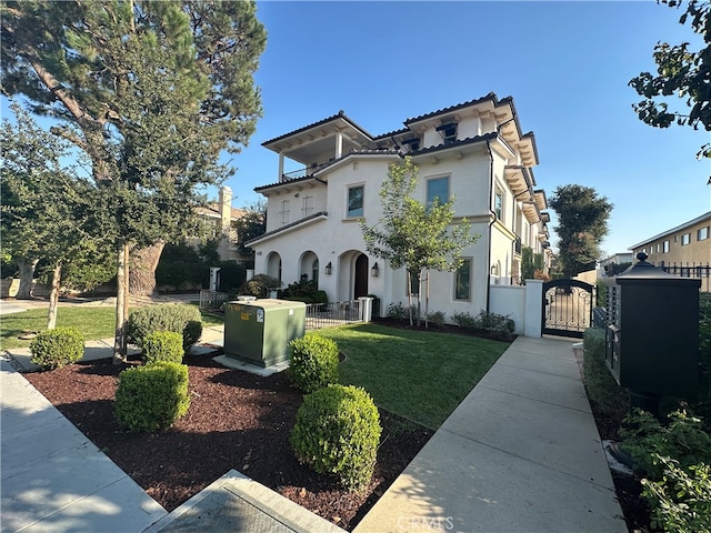 mediterranean / spanish-style home featuring a balcony and a front yard