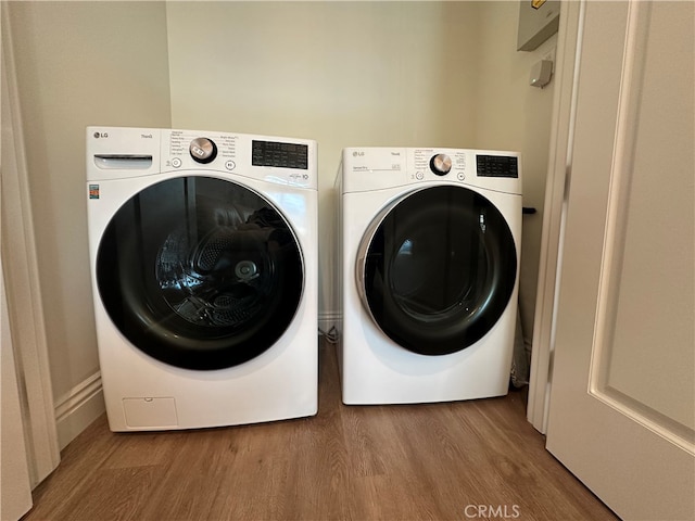 clothes washing area featuring washer and dryer and hardwood / wood-style floors