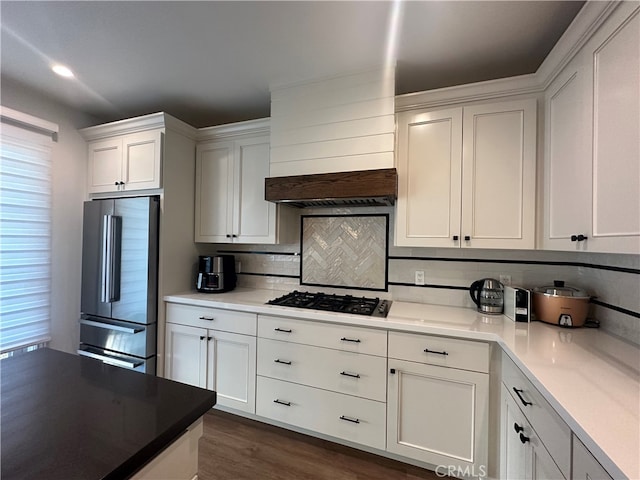 kitchen featuring decorative backsplash, stainless steel appliances, white cabinets, dark hardwood / wood-style flooring, and custom exhaust hood