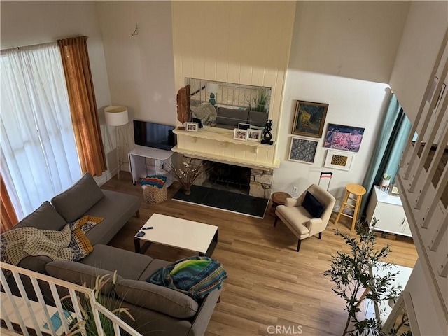 living room featuring a stone fireplace and hardwood / wood-style floors