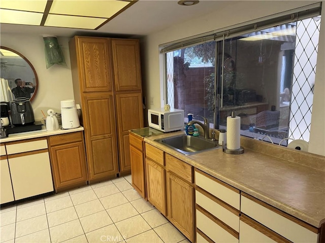 kitchen featuring light tile patterned floors and sink