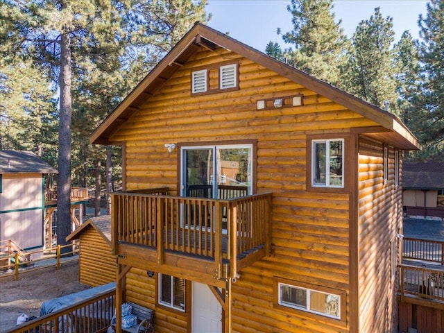 rear view of house featuring a deck and a balcony