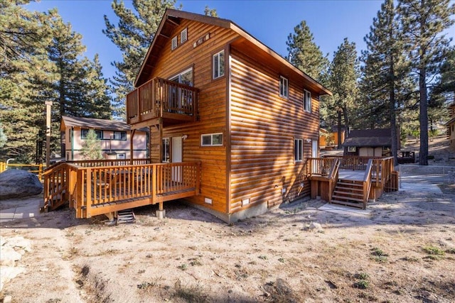 back of house featuring a balcony and a deck