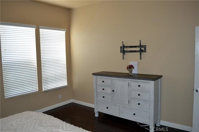 bedroom with dark hardwood / wood-style flooring