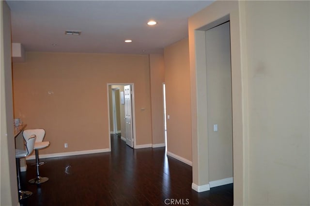 corridor with dark hardwood / wood-style flooring