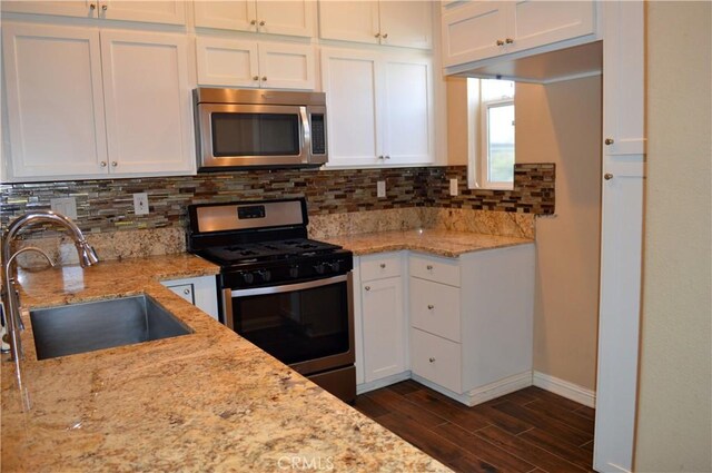 kitchen featuring white cabinetry, sink, light stone countertops, and appliances with stainless steel finishes