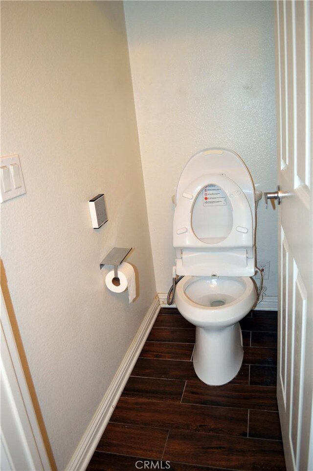 bathroom with hardwood / wood-style floors and toilet